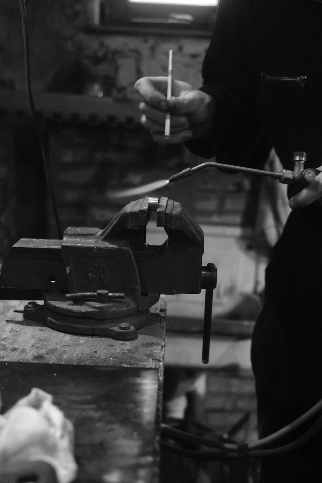 Soldering a piece with a torch and tongs