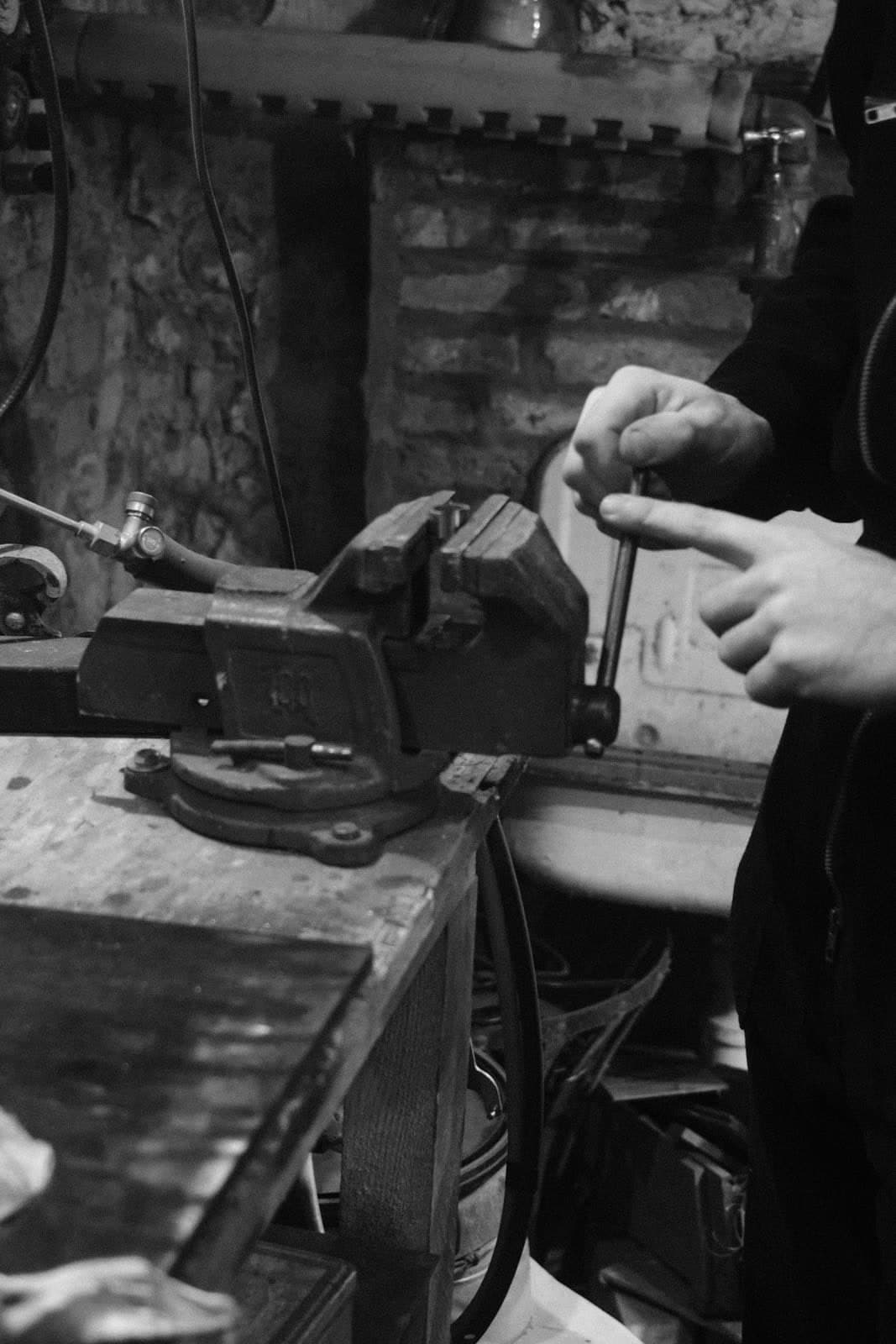 Hands adjusting a piece held in a workbench vice